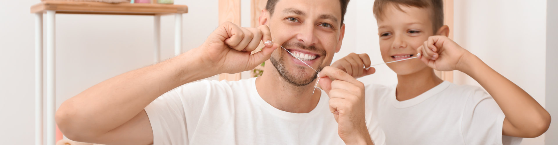 little boy and his father flossing teeth