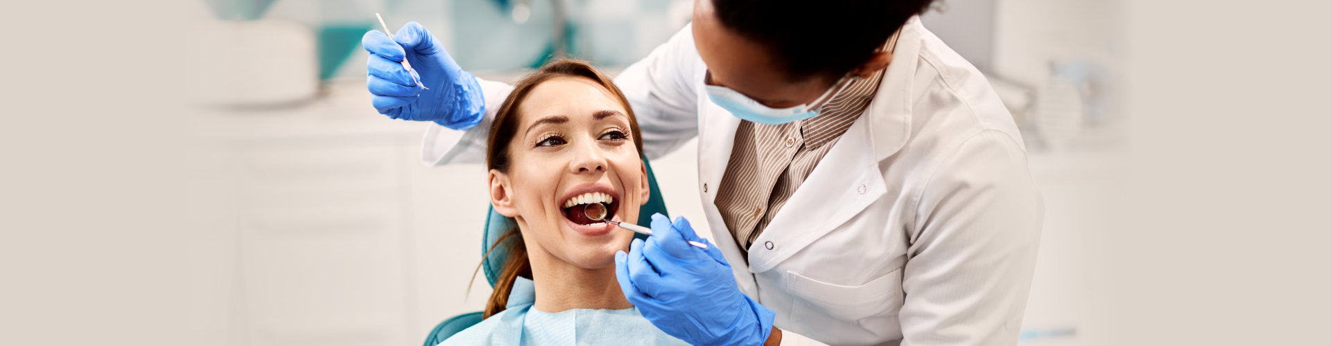 young woman having her mouth checked by dentist