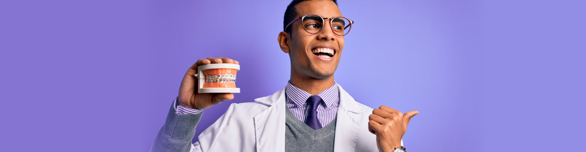 dentist man holding denture teeth with dental braces