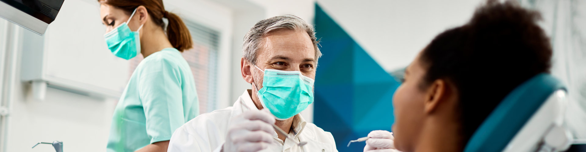 dentist with face mask talking to his patient